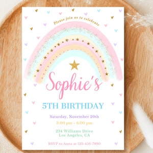 Peut inclure: Une invitation d'anniversaire sur le thème de l'arc-en-ciel avec un arc-en-ciel rose, bleu et jaune avec des paillettes dorées et des étoiles. Le texte "Sophie's 5th Birthday" est en bleu et rose. L'invitation comprend la date, l'heure, l'adresse et les informations RSVP.