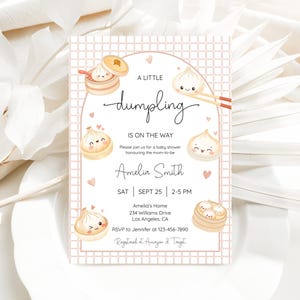 May include: A baby shower invitation with a pink grid background and dumpling illustrations. The text reads "A Little Dumpling Is On The Way" with details for Amelia Smith's baby shower, including the date, time, and location.