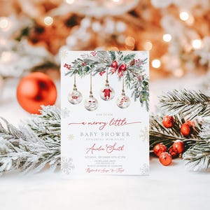 May include: A Christmas baby shower invitation with a festive design. The invitation has a white background with a decorative garland, baubles, and the text "a merry little baby shower". The invitation is for Amelia Smith.