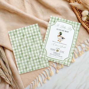 May include: Baby shower invitation with a green and white gingham pattern. The invitation features a watercolor illustration of a duck and the text "A Baby Boy Is On His Way!" The invitation includes event details.