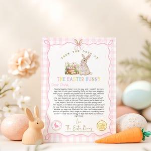 Puede incluir: Una tarjeta rosa y blanca a cuadros vichy con un conejito de dibujos animados sosteniendo una cesta de huevos de Pascua. La tarjeta dice "From the Desk of The Easter Bunny" y est&aacute; dirigida a Olivia. La tarjeta incluye un mensaje del Conejo de Pascua sobre esconder huevos de Pascua y sorpresas.