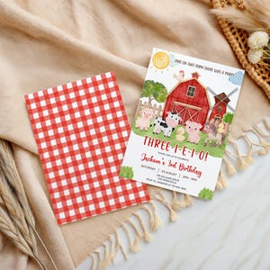 Op de afbeelding: Een verjaardagskaart met boerderijthema met een rood-wit geruite kaart. De uitnodiging toont een rode schuur, een windmolen en cartoon dieren. Tekst luidt "THREE-I-E-I-O!" en "Jackson's 3rd Birthday."