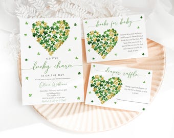 Op de afbeelding: Drie afdrukbare kaarten voor een babyshower. De kaarten zijn wit met groene klaverbladontwerpen en gouden glitter. De eerste kaart zegt "Een klein geluksbrenger is onderweg". De tweede kaart zegt "Boeken voor baby" en de derde kaart zegt "Luiers loterij".