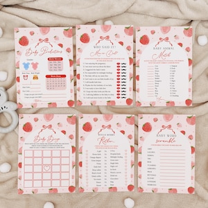 May include: Set of six pink and white baby shower game cards with strawberry and bow designs. The games include Baby Predictions, Who Said It, Baby Animal Match, Baby Bingo, Would Mommy Rather, and Baby Word Scramble.