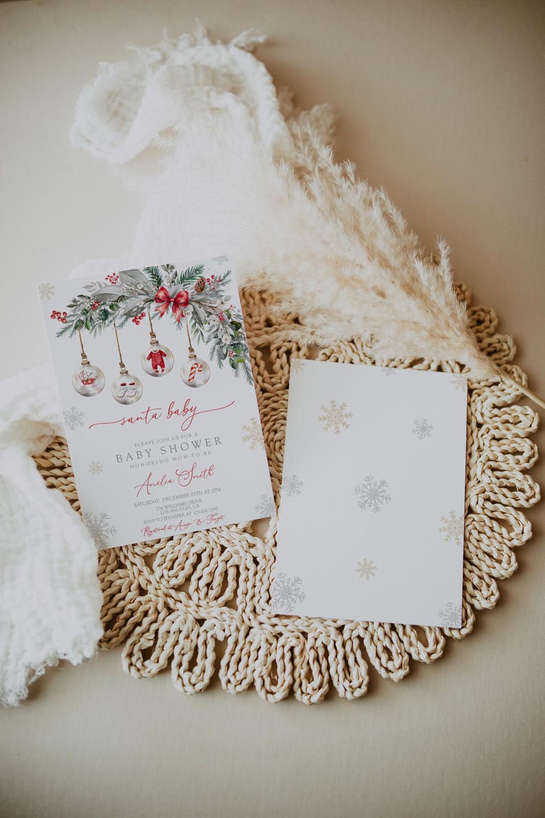 May include: A baby shower invitation with a Christmas theme. The invitation features a watercolor design with ornaments, snowflakes, and greenery. The text reads "Santa Baby" and includes event details. A matching card with snowflake patterns is also present.