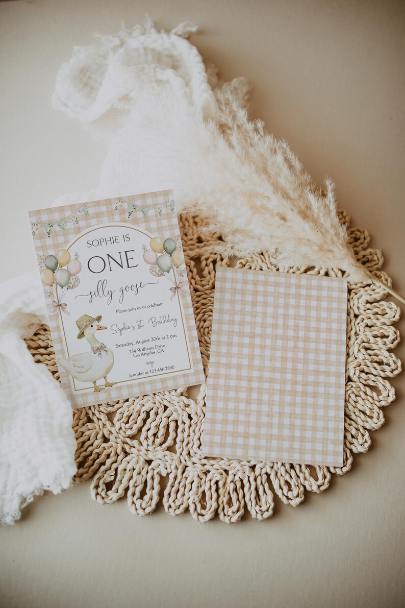 May include: A light brown and white gingham patterned invitation with a white goose illustration and the text "Sophie is One silly goose" and "Sophie's 1st Birthday".