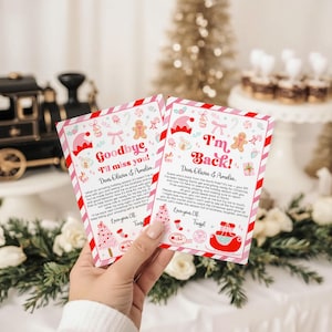 May include: Two Christmas-themed cards with pink and red borders are held in a hand. The cards have festive illustrations of elves, gingerbread men, and Christmas trees. One card reads "Goodbye I'll miss you!" and the other says "I'm Back!"