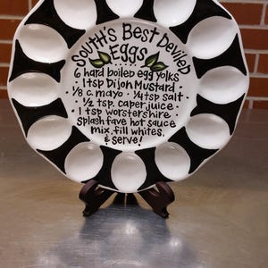 May include: A handmade wooden sign with the text "Welcome to our home" in a handwritten style. The sign is painted white with black lettering and a distressed finish, suitable for indoor or outdoor use.