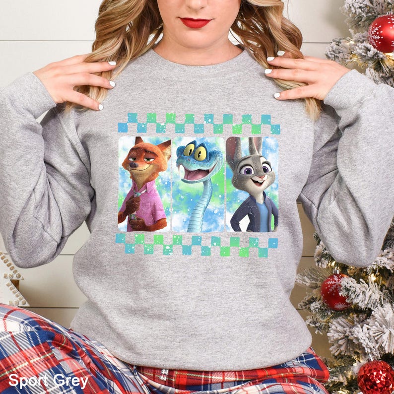 A woman wearing a grey sweatshirt with a graphic design featuring cartoon animal characters.