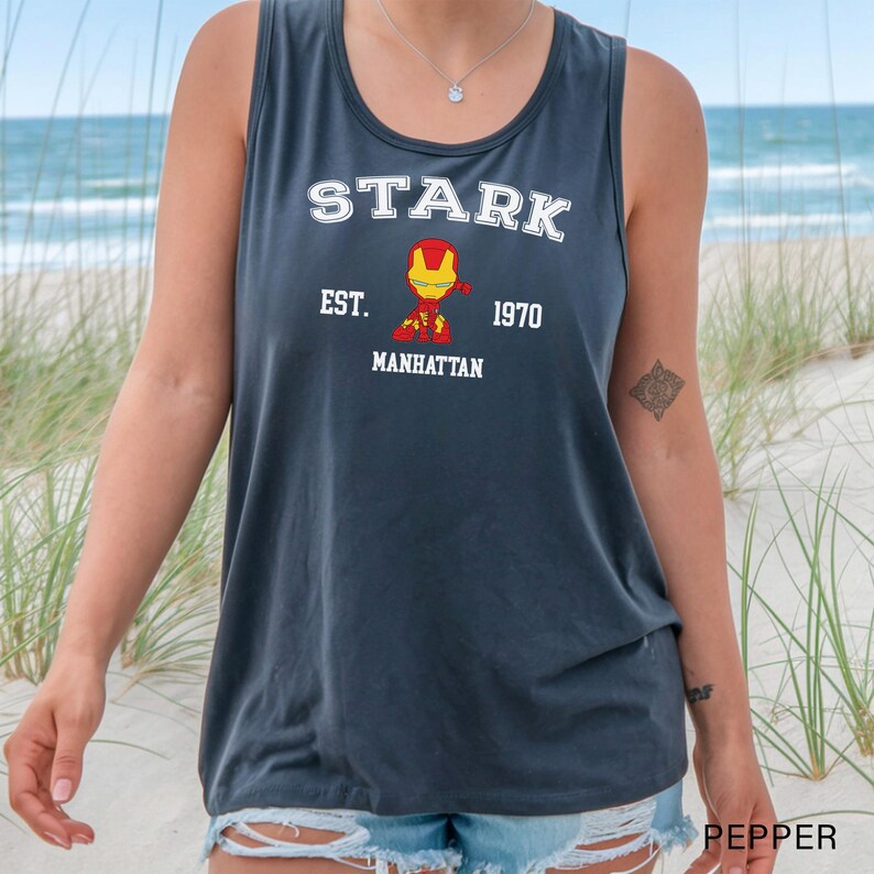 A person wearing a grey tank top with a graphic of a character from the Marvel Cinematic Universe, specifically Iron Man, printed on it.