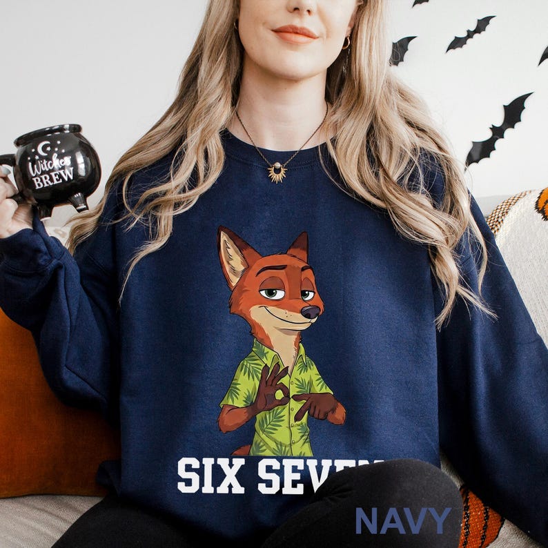 A woman wearing a navy blue sweatshirt with a cartoon image of a fox character and the text "Six Seven Navy" printed on it.