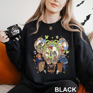 A woman wearing a black sweatshirt with a colorful graphic of characters from a cartoon or animated series.