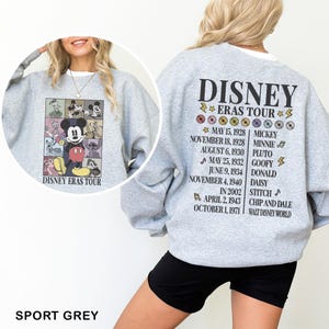 a woman wearing a sweatshirt with a mickey mouse graphic on it