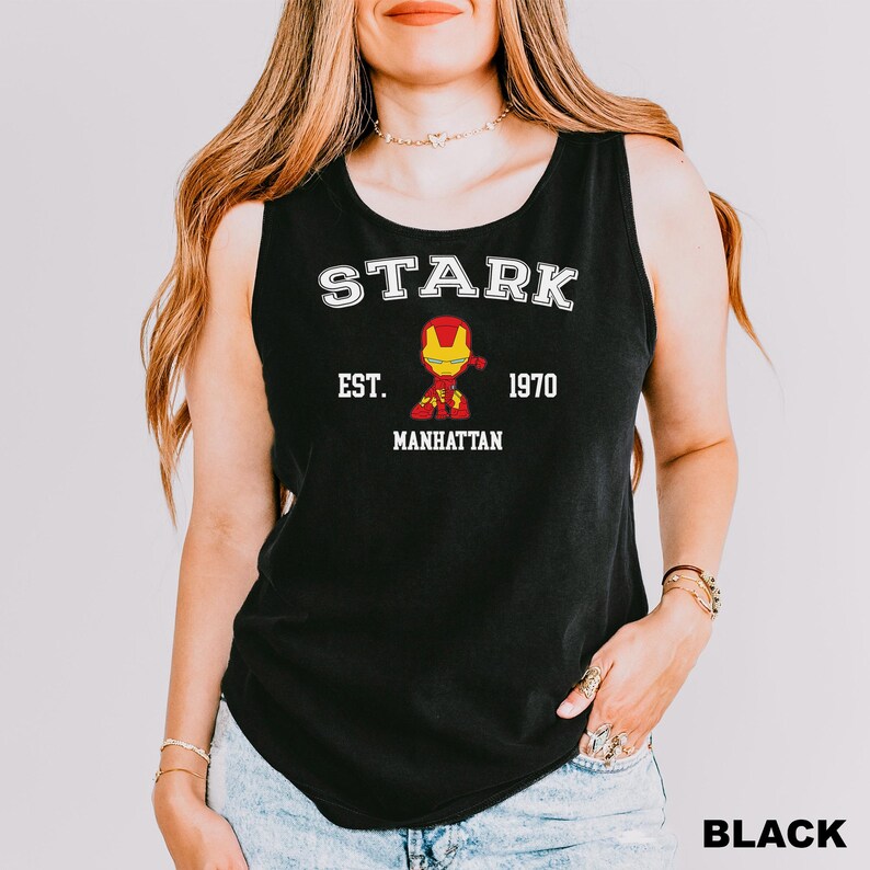 A woman wearing a black tank top with the text "STARK EST. 1970 MANHATTAN" printed on it, along with an illustration of a character from the Marvel Cinematic Universe.