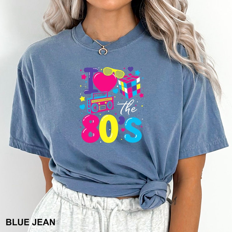 a woman wearing a blue t - shirt with the words the 80s on it