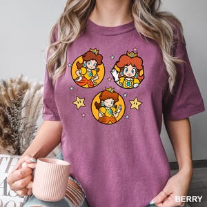 a woman is holding a cup and wearing a t - shirt