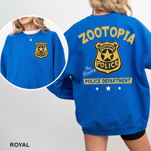 A woman wearing a blue sweatshirt with the text "Zootopia Police Department" printed on it.