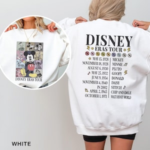 a woman wearing a white disney sweatshirt with a picture of mickey mouse on it