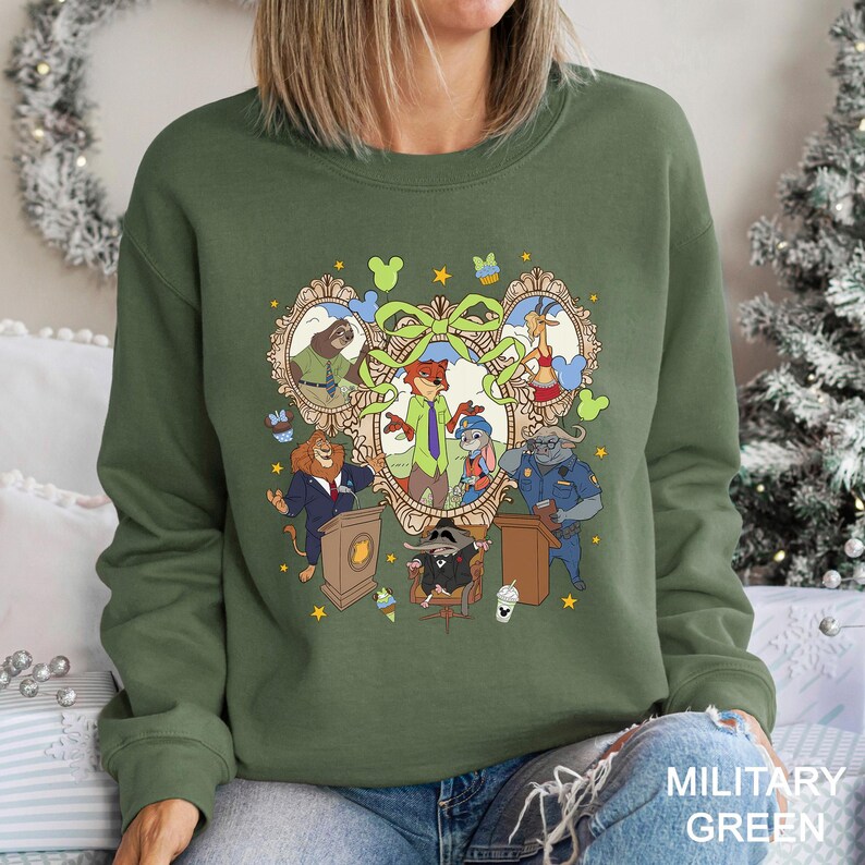 A woman wearing a green sweatshirt with a colorful graphic design featuring cartoon characters and various objects.