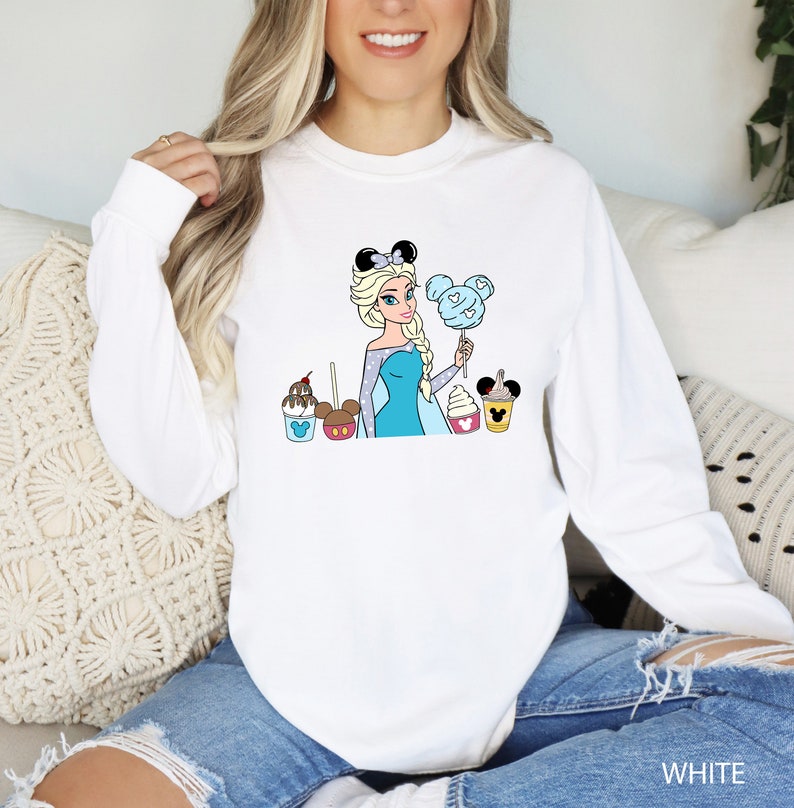 a woman sitting on a couch wearing a white sweatshirt