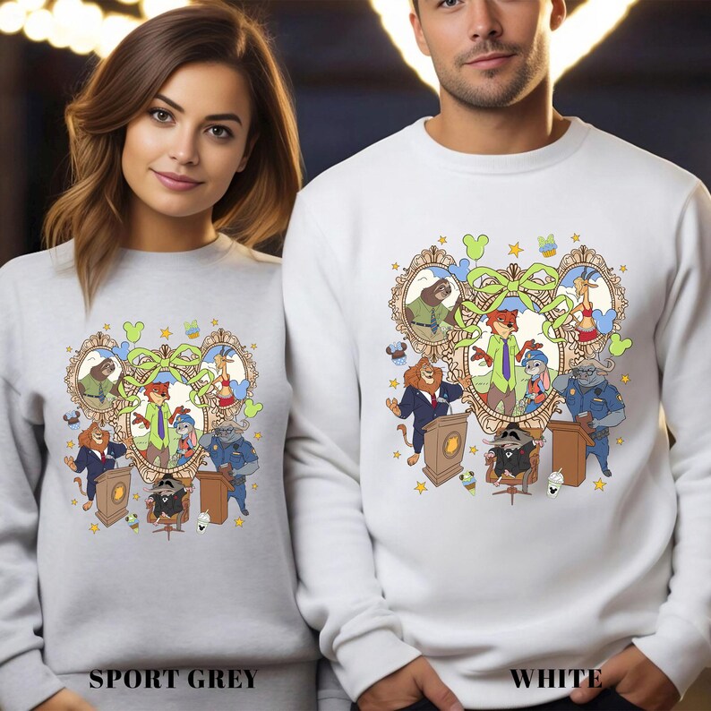 Two people wearing white sweatshirts with a colorful cartoon-style illustration of characters from Disney's "The Little Mermaid".