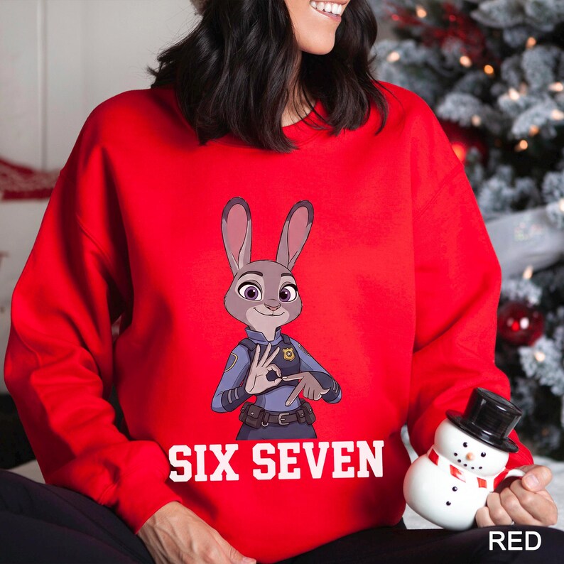 A woman wearing a red sweater with a cartoon image of a police officer and the text "SIX SEVEN" printed on it.