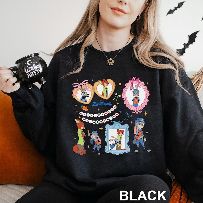 A woman wearing a black sweatshirt with a colorful graphic design featuring cartoon characters and text.