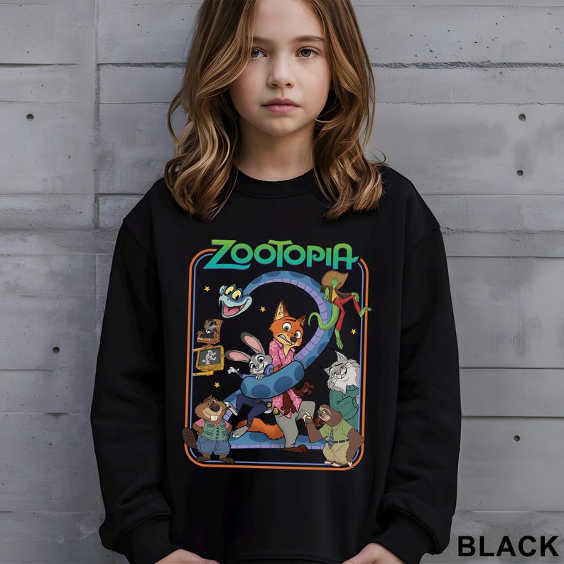 A young girl wearing a black sweatshirt with a colorful graphic of characters from the animated film "Zootopia" on it.