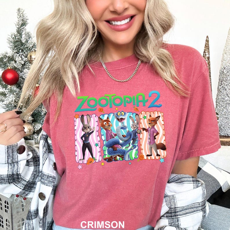 A woman wearing a pink t-shirt with a graphic of the characters from the animated film "Zootopia 2".