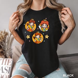 a woman wearing a black tshirt with cartoon characters on it