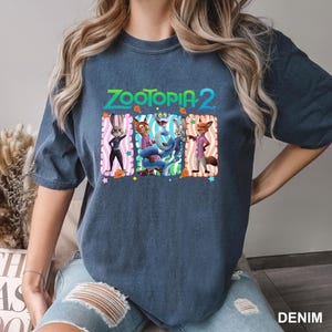 A woman wearing a blue t-shirt with a graphic design featuring cartoon animal characters from the movie Zootopia.