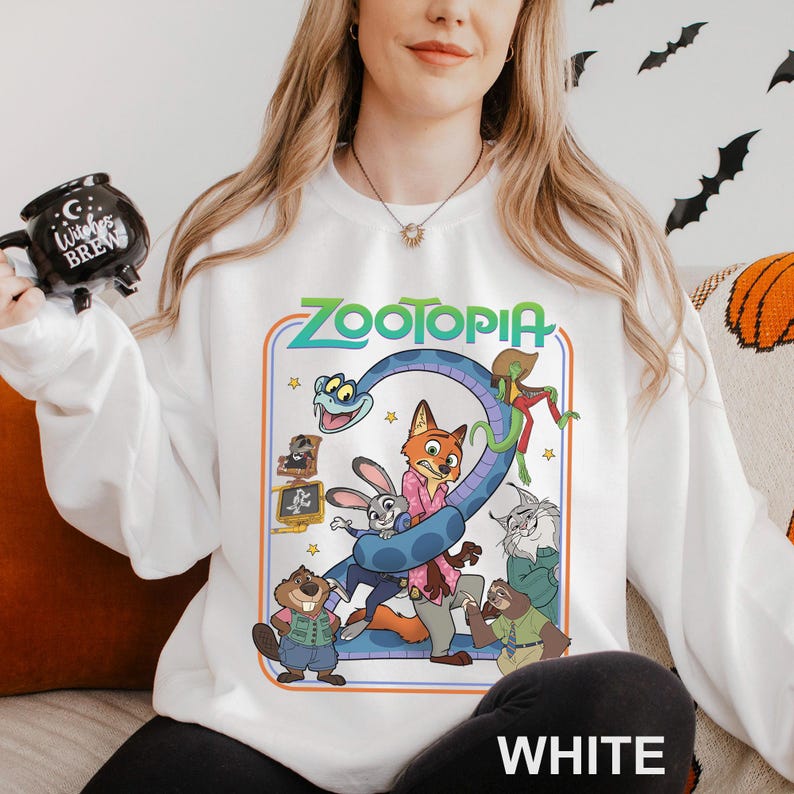 A woman wearing a white sweatshirt with a colorful graphic of the characters from the animated film "Zootopia" on it.