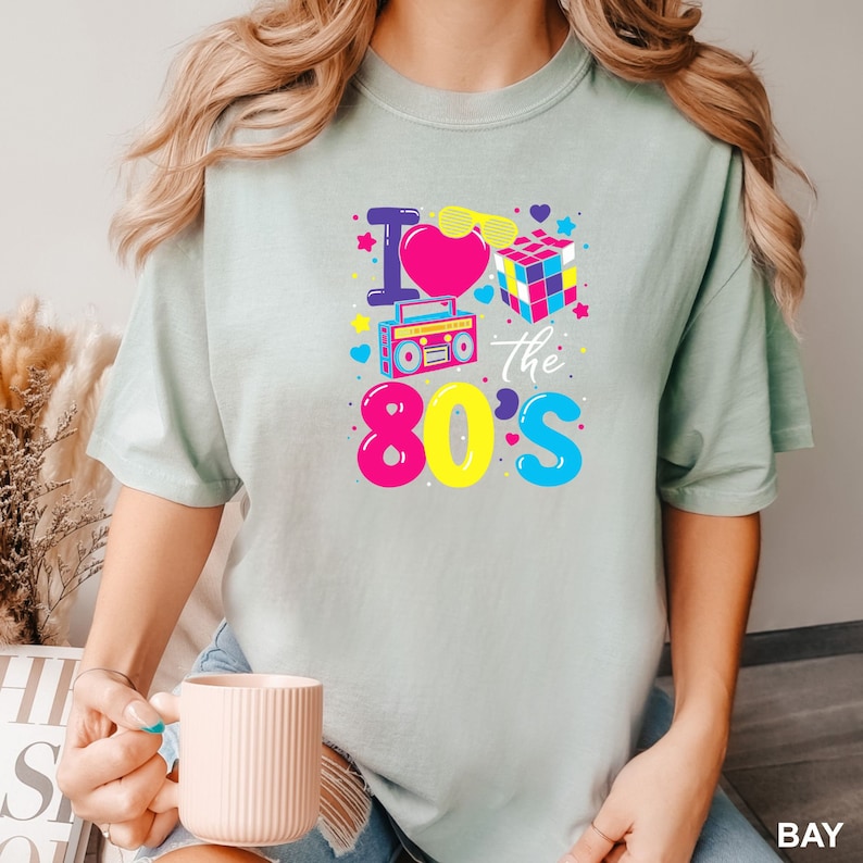 a woman is holding a cup and wearing a t - shirt