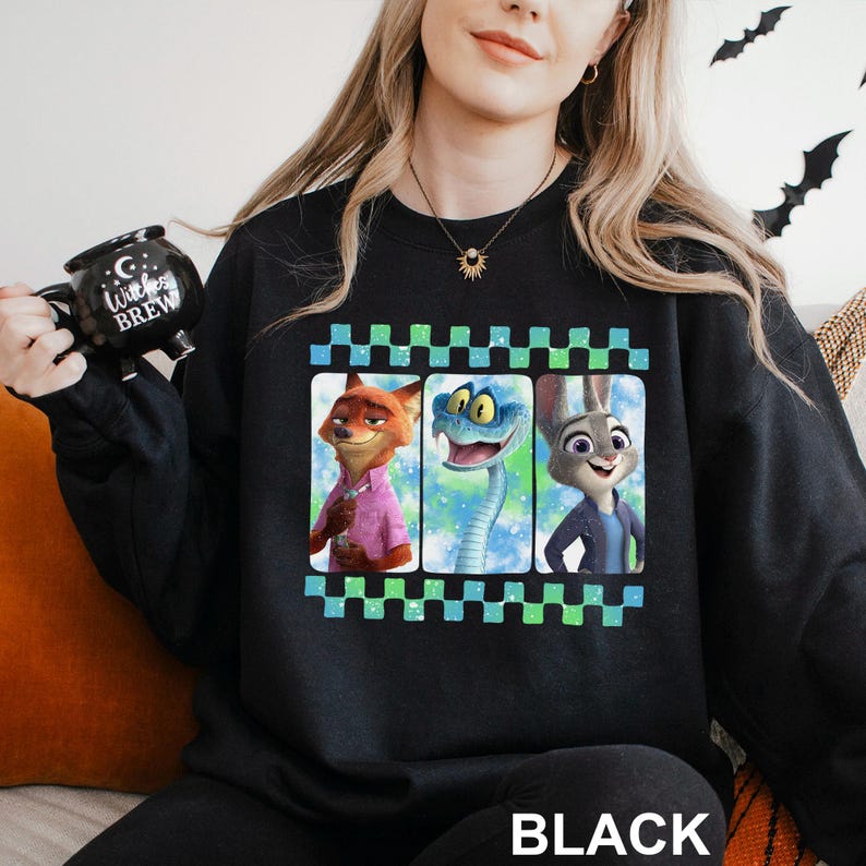 A woman wearing a black sweatshirt with a graphic of three cartoon animal characters on it, including a fox, a snake, and a rabbit.