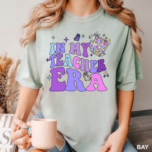 a woman holding a coffee cup and wearing a tshirt