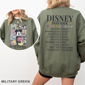 a woman wearing a green sweatshirt with mickey mouse on it