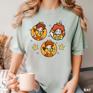 a woman is holding a coffee cup and wearing a t - shirt