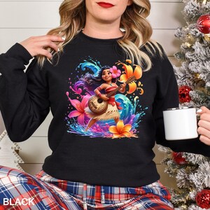 a woman holding a coffee mug in front of a christmas tree