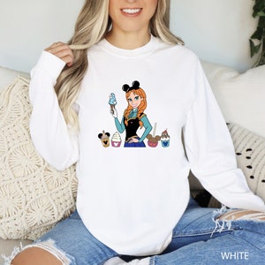 a woman sitting on a couch wearing a mickey mouse shirt