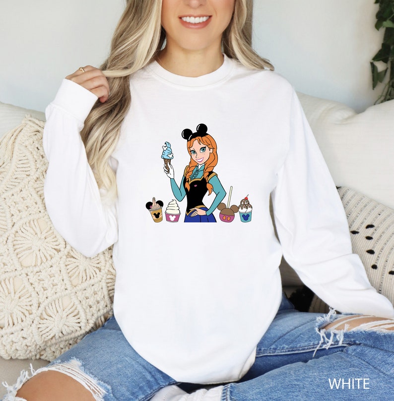 a woman sitting on a couch wearing a mickey mouse shirt
