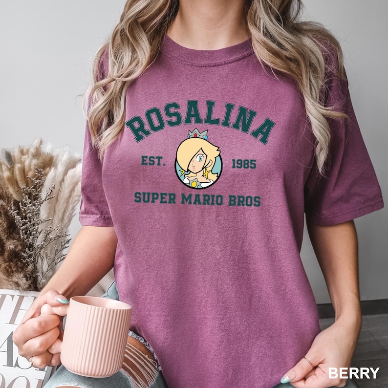 A woman wearing a purple t-shirt with a graphic of a character from the Super Mario Bros. video game franchise.