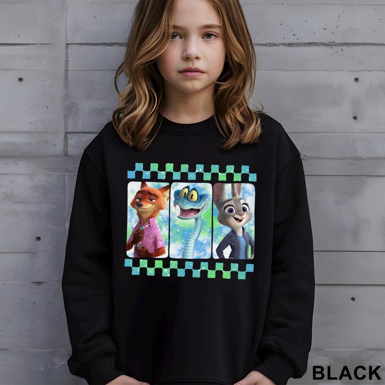 A young girl wearing a black sweatshirt with a graphic design featuring three cartoon animal characters.
