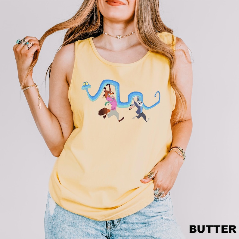 A woman wearing a yellow tank top with a cartoon character design and holding her hair.