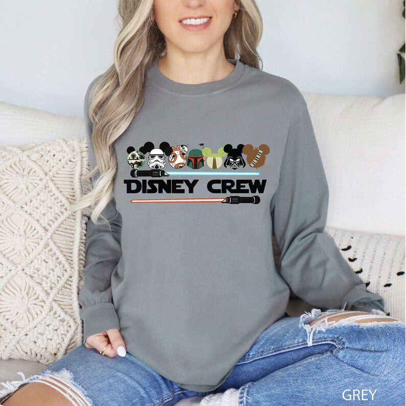 a woman sitting on a couch wearing a disney crew shirt
