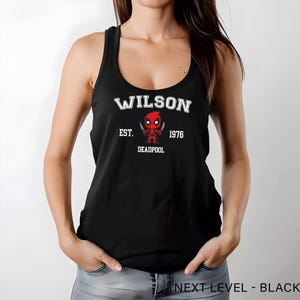 A woman wearing a black tank top with a graphic of a character from the Marvel Cinematic Universe.