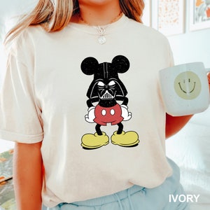 a woman wearing a mickey mouse shirt holding a coffee mug