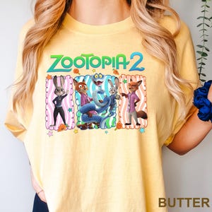 A yellow t-shirt with a graphic design featuring characters from the animated film "Zootopia 2".
