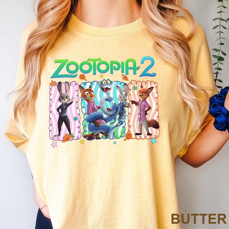 A yellow t-shirt with a graphic design featuring characters from the animated film "Zootopia 2".
