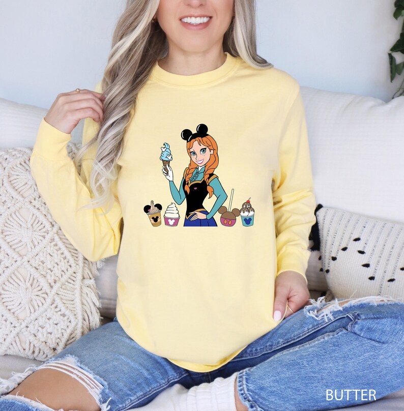 a woman sitting on a couch wearing a yellow shirt