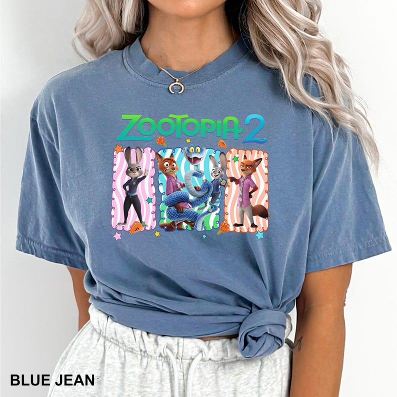 A woman wearing a blue t-shirt with a graphic of the Zootopia 2 characters.